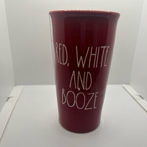 Rae Dunn red white and booze ceramic travel mug with plastic lid.